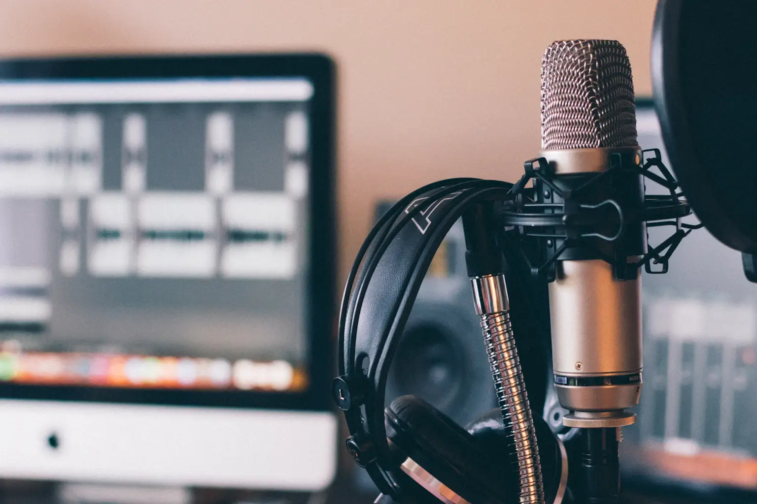 Professional podcast and radio studio setup with microphone headphones and desktop showing content management workflow for show preparation