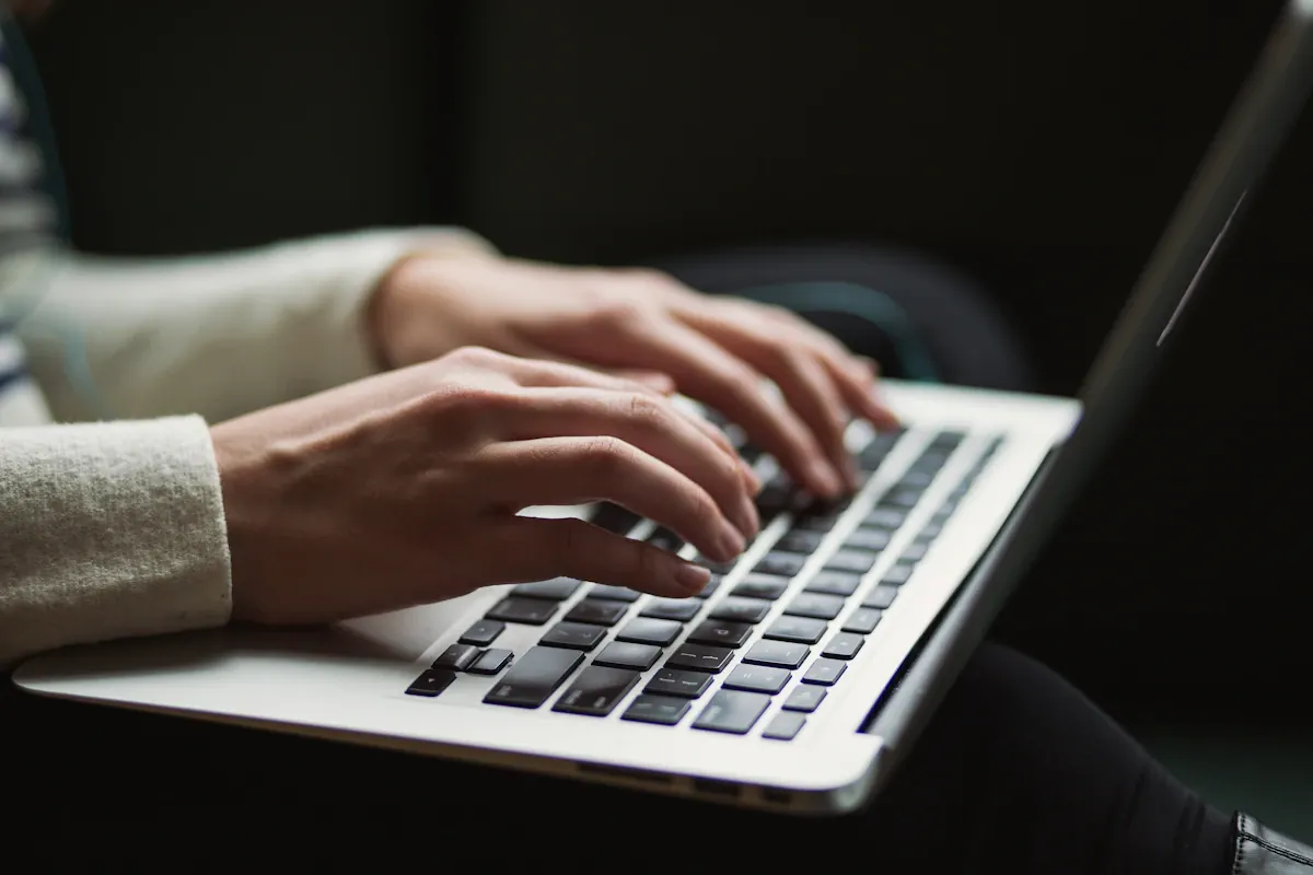 Person writing content on a laptop at a clean workspace representing the blog creation and show prep workflow with Radio Content Pro