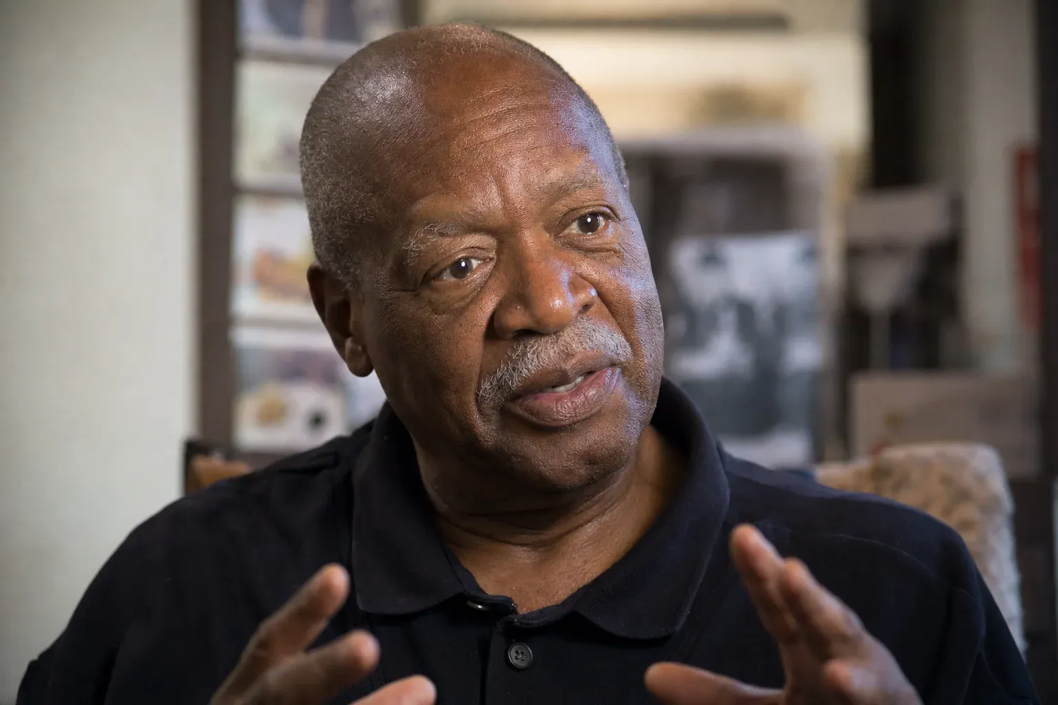 Intimate close portrait of a Black community elder mid-conversation sharing oral history representing genuine community voices in Juneteenth radio content programming