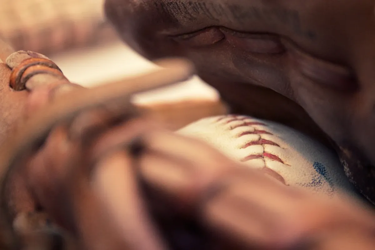 Close-up of a baseball bat and glove on the field representing the start of MLB season and Opening Day radio content planning