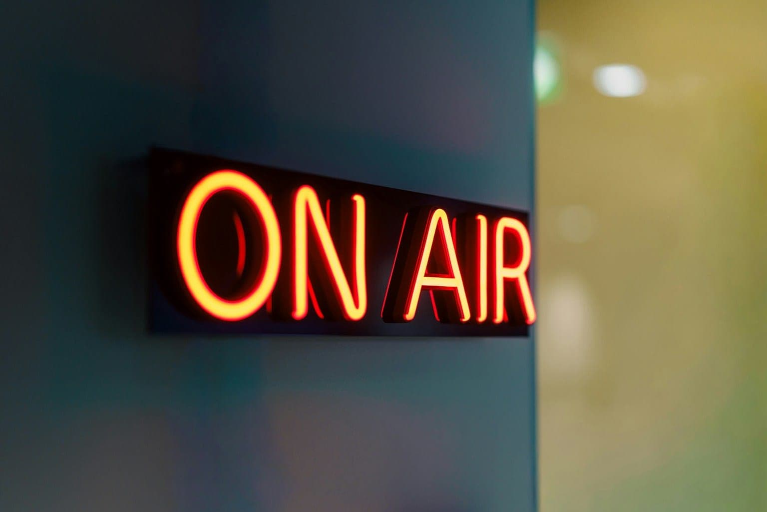 Red neon On Air sign glowing in radio studio representing live broadcasting