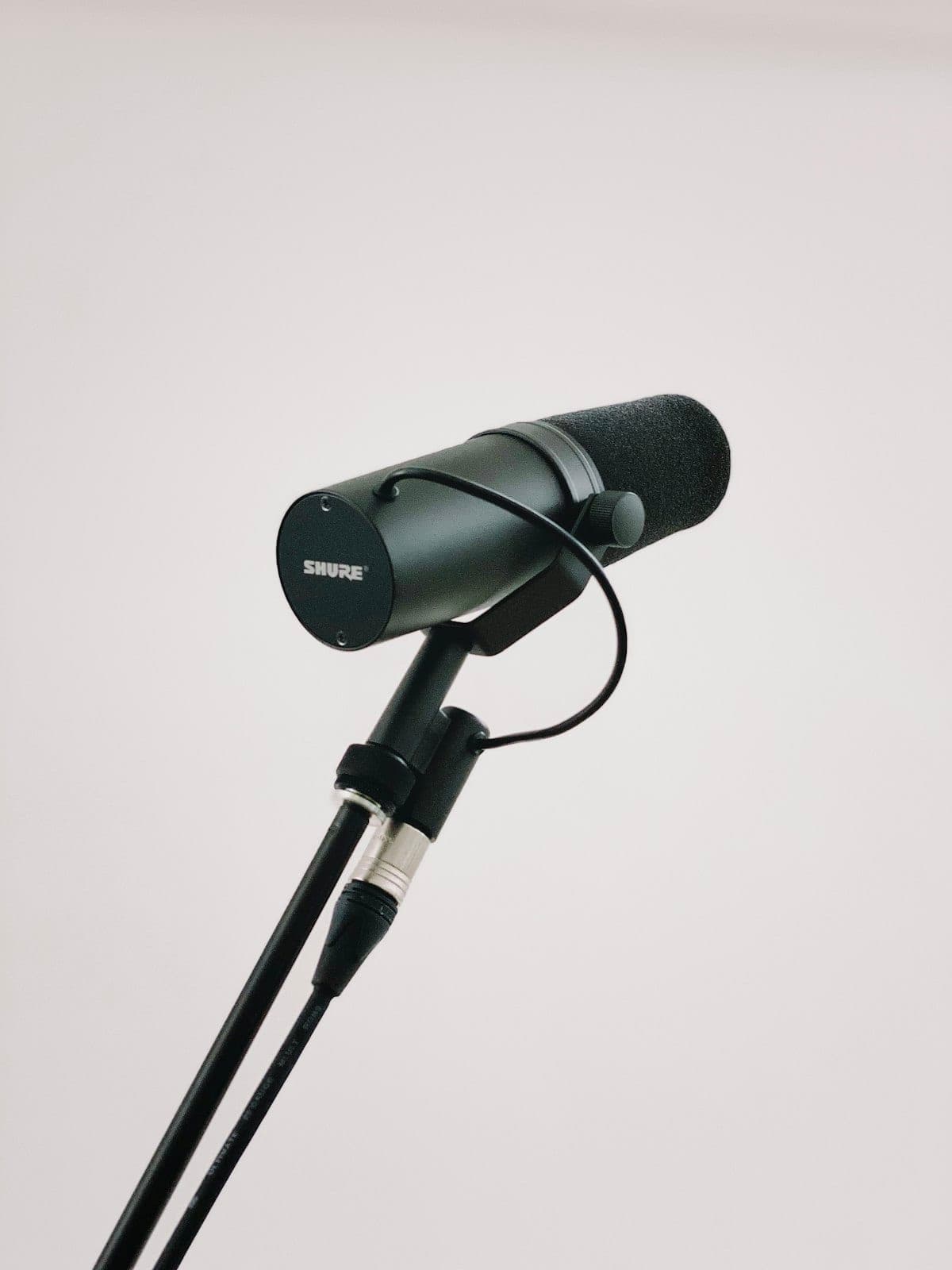 Professional studio microphone on stand representing radio broadcast equipment for afternoon drive programming