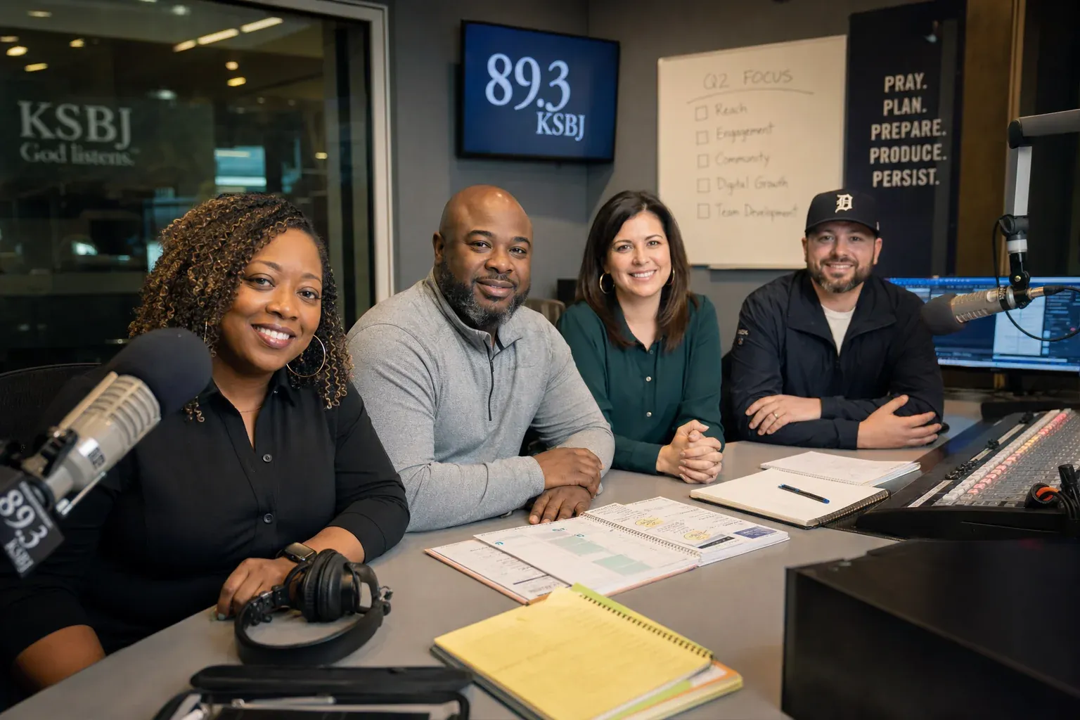 A confident radio team in a modern studio with content organized, in control of the back half of the ratings book