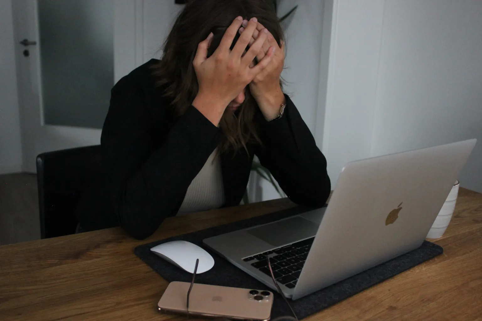 Woman covering her face while looking at laptop computer, showing the frustration of overwhelming show prep work