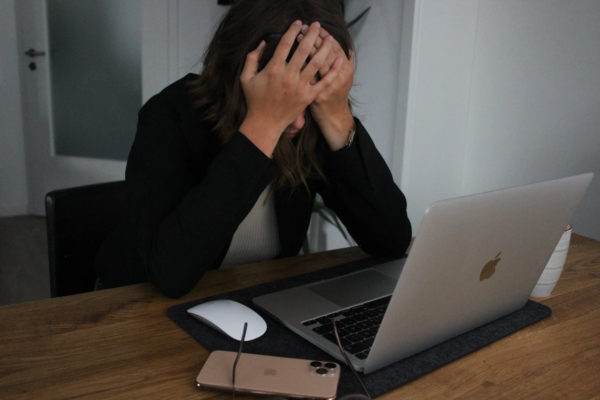 Woman covering her face while looking at laptop computer, showing the frustration of overwhelming show prep work