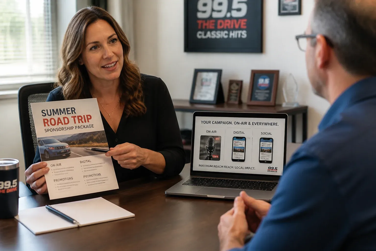 Radio account executive presenting a themed Summer Road Trip sponsorship package to a local advertiser, on-air and digital elements shown together on a laptop screen