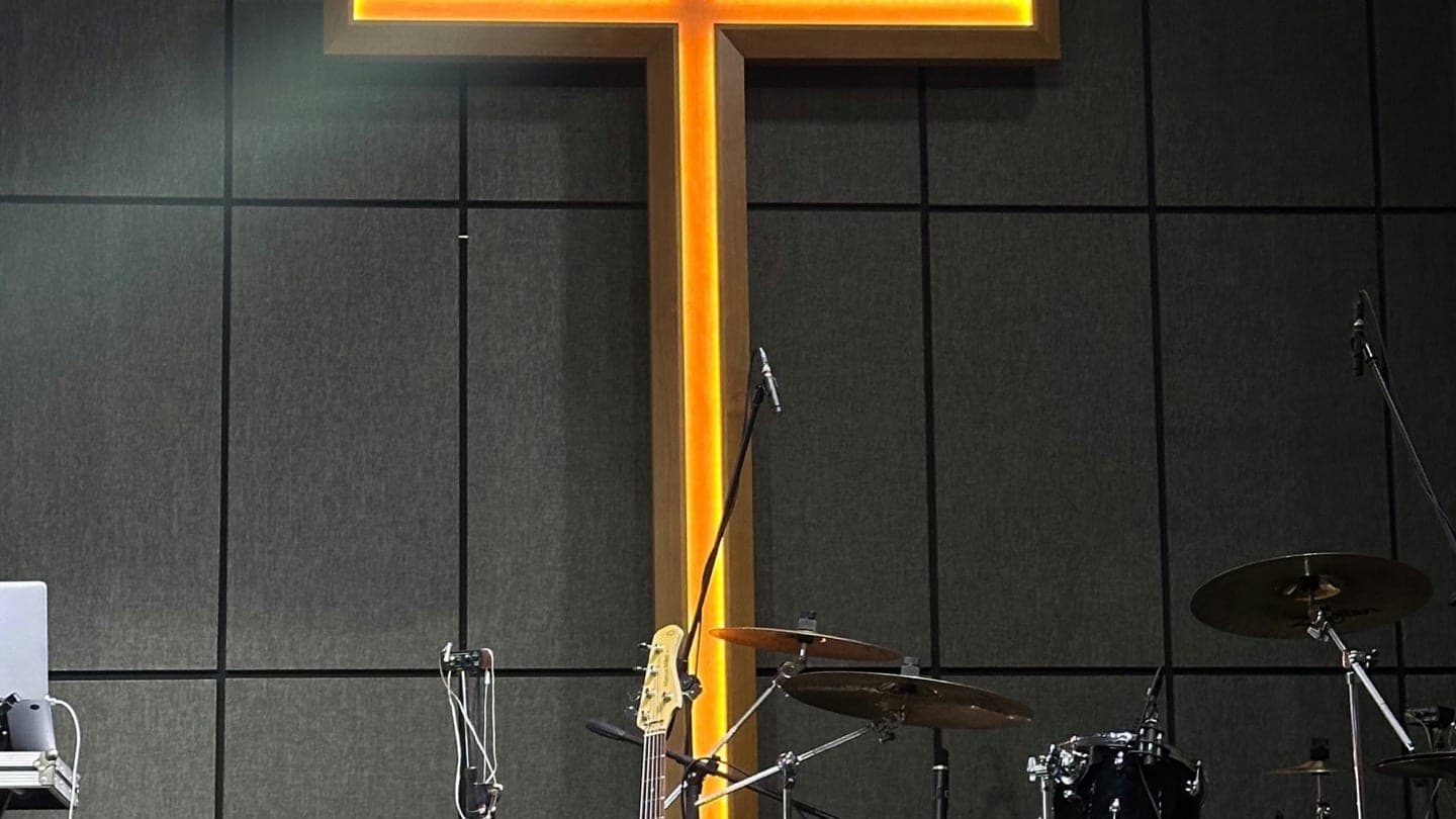 A cross on a worship stage with musical instruments